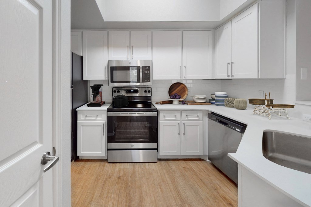 a kitchen with white cabinets and stainless steel appliances  at Hayden on West Ave, San Antonio, TX