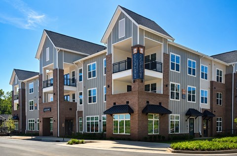 A modern apartment building with a mix of brick and siding exterior.