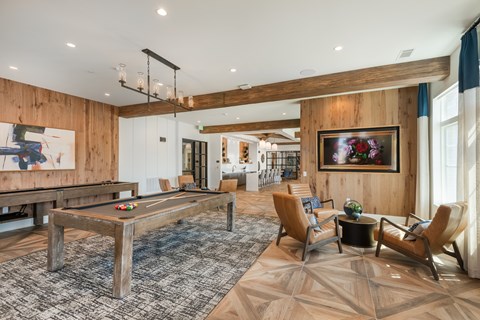 A room with a pool table and a painting on the wall.