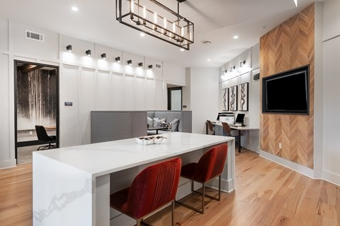 A modern dining room with a white table and red chairs.