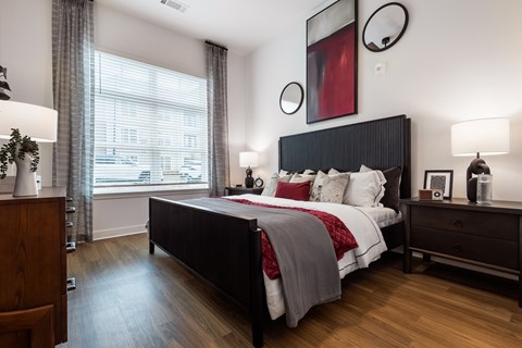 A bedroom with a large bed and a wooden dresser.