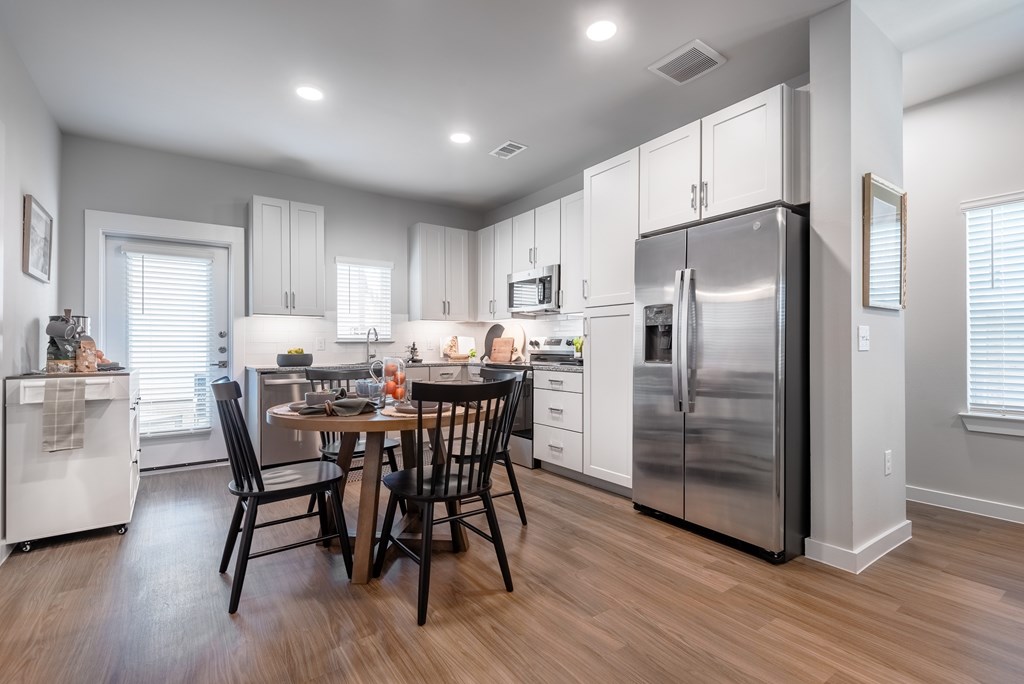 A kitchen with a table and chairs in the middle of it.
