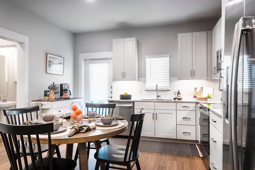 A modern kitchen with a dining table set for two.