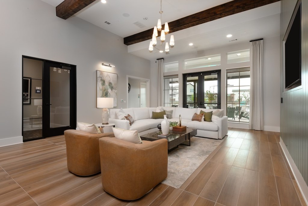 A modern living room with a white sofa and wooden floors.