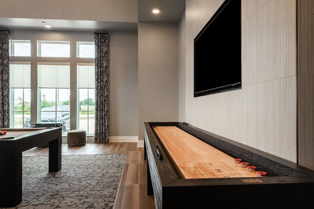 A pool table with a television mounted on the wall.
