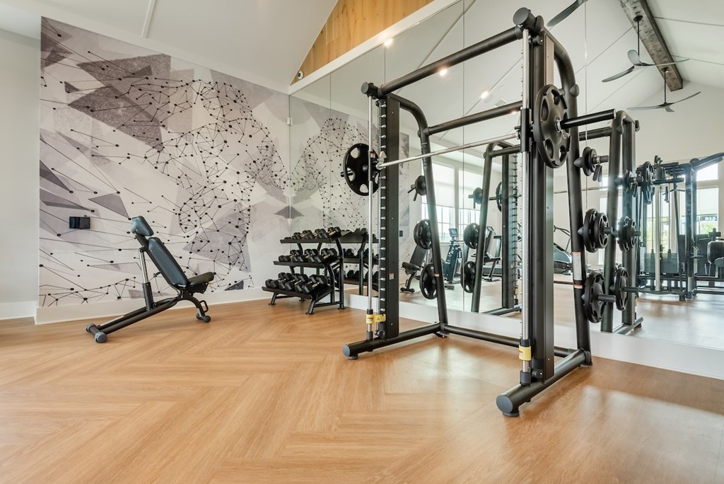 A gym with a wooden floor and a wall with a black and white geometric pattern.