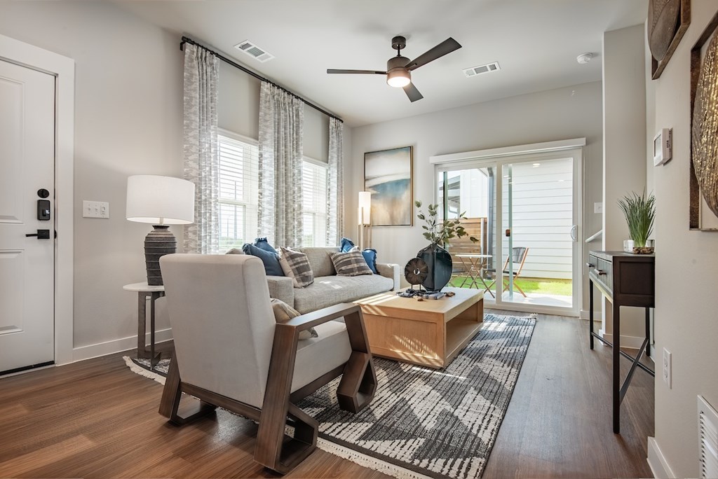 A living room with a white chair, a wooden coffee table, and a rug.