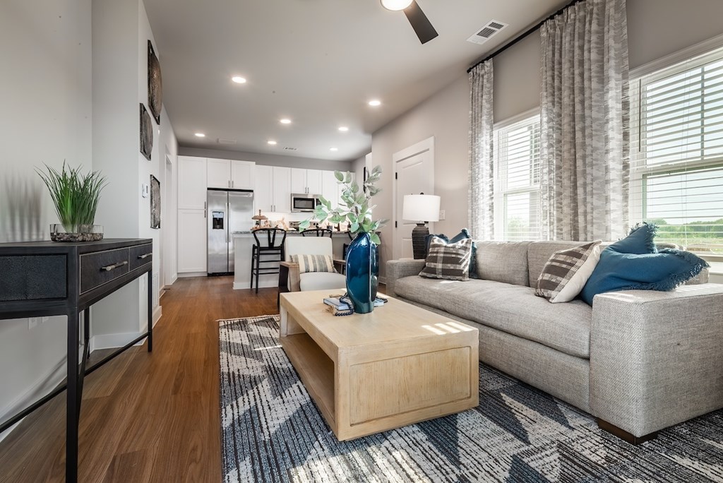 A modern living room with a grey couch and a wooden coffee table.