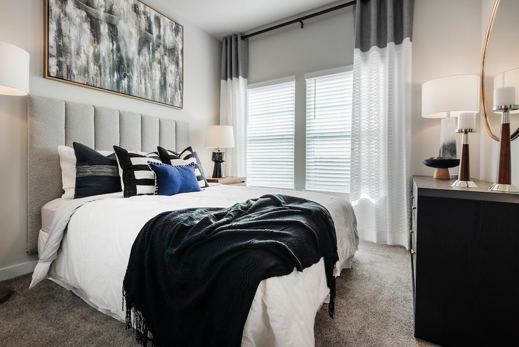 A bedroom with a large bed and a painting on the wall.