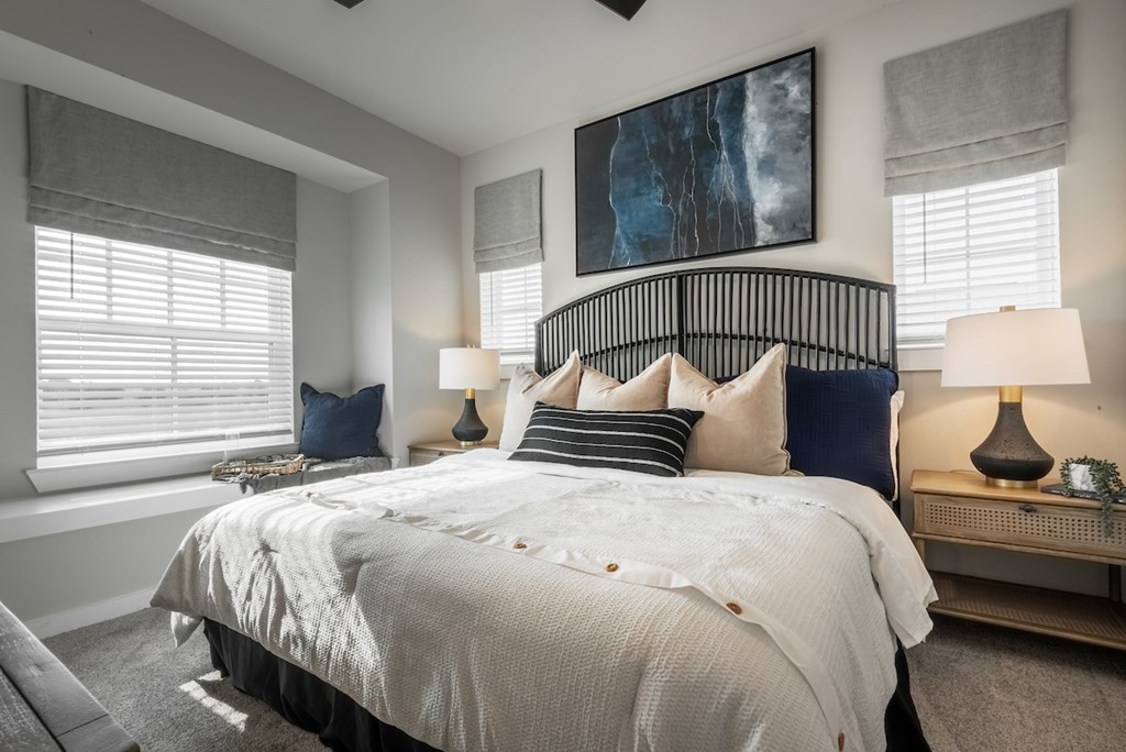 A bedroom with a large bed and a painting on the wall.