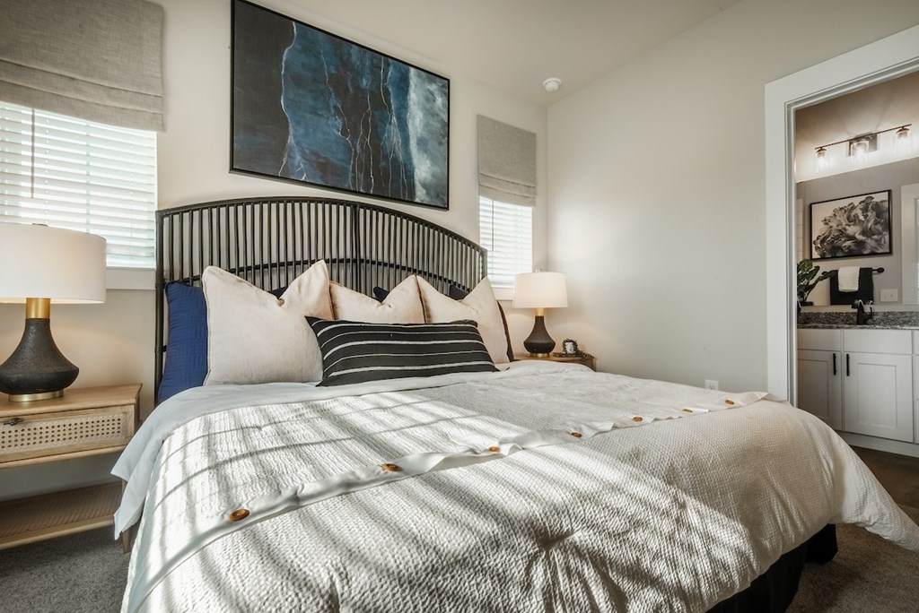 A bedroom with a large bed and a painting on the wall.