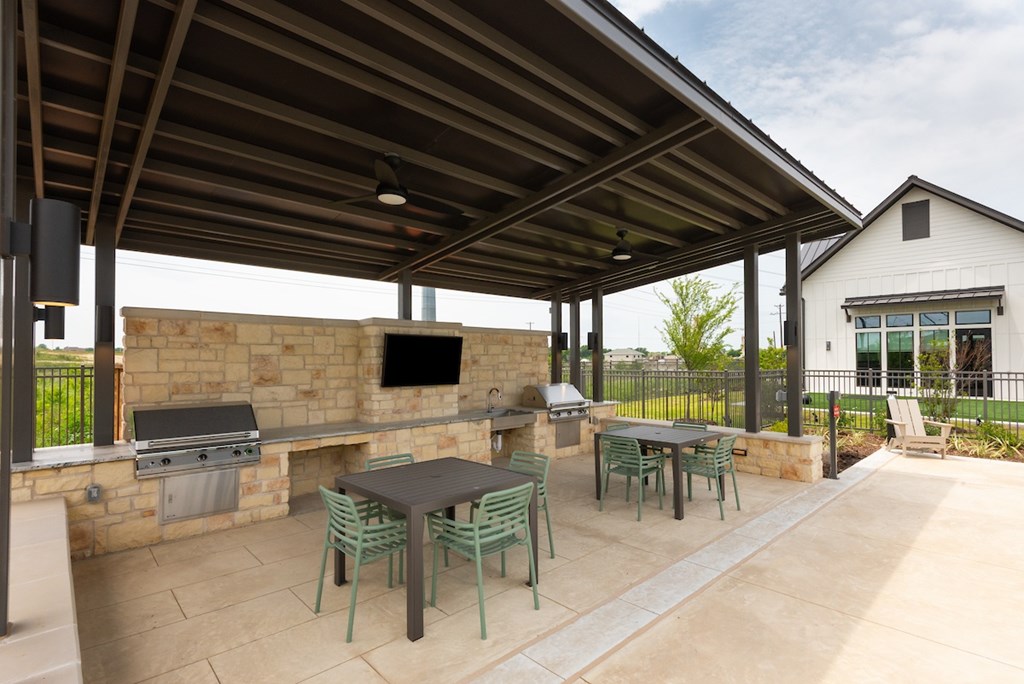 A patio with a table and chairs under a roof.
