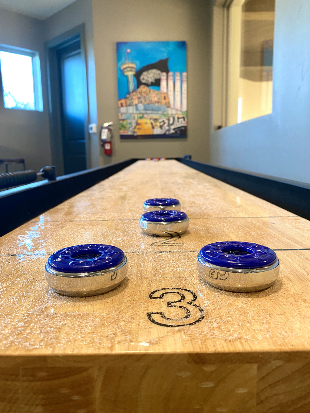 shuffleboard inside the game room at mela's luxury apartments
