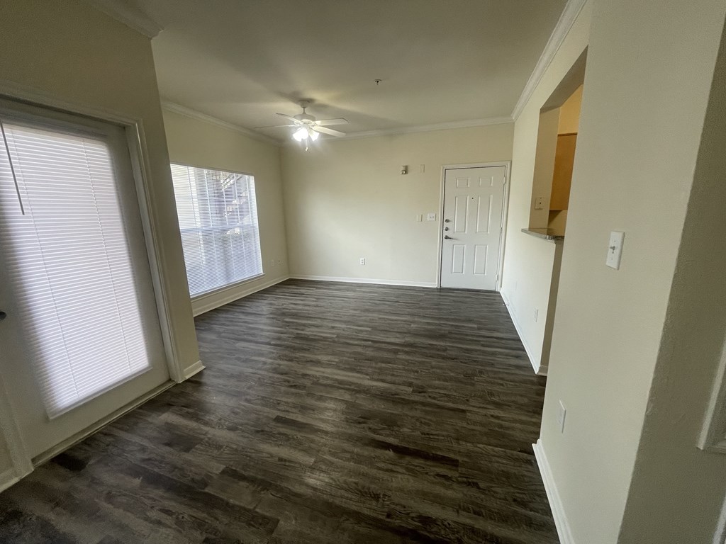 A room with wooden flooring and a window with blinds.