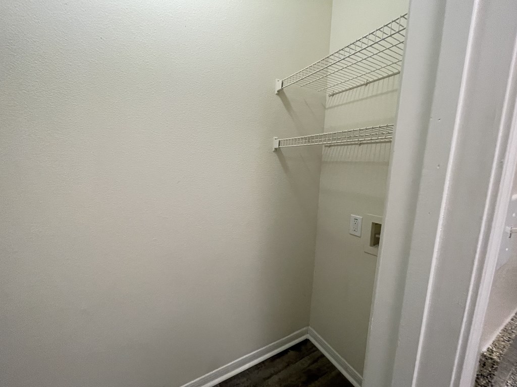 A white wall with a shelf and a switchboard.