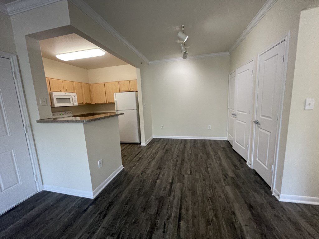 A kitchen area with a microwave, oven, and refrigerator.