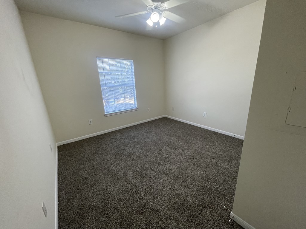 A room with a ceiling fan and a window showing a snowy scene outside.