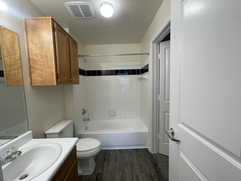 A bathroom with a white toilet, sink, and bathtub.