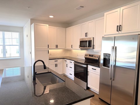 A kitchen with white cabinets and stainless steel appliances.