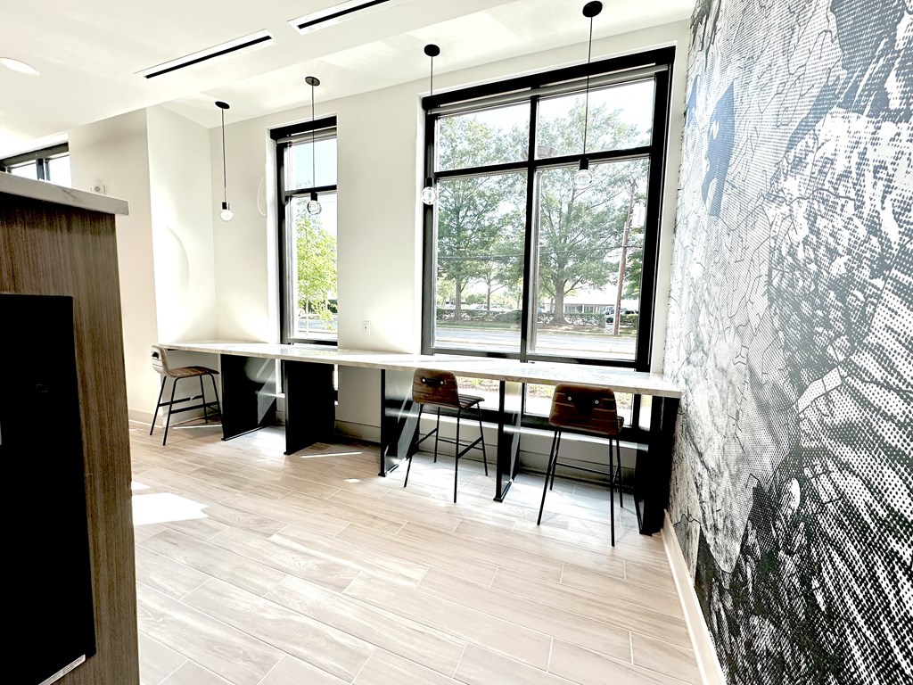 A room with a long table and chairs with a black and white wallpaper.