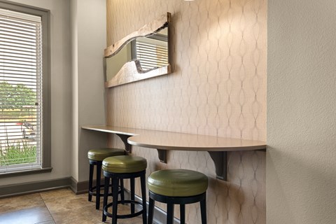 a bar with four stools and a mirror on the wall