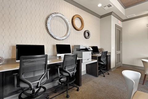 a computer room with desks and chairs and monitors