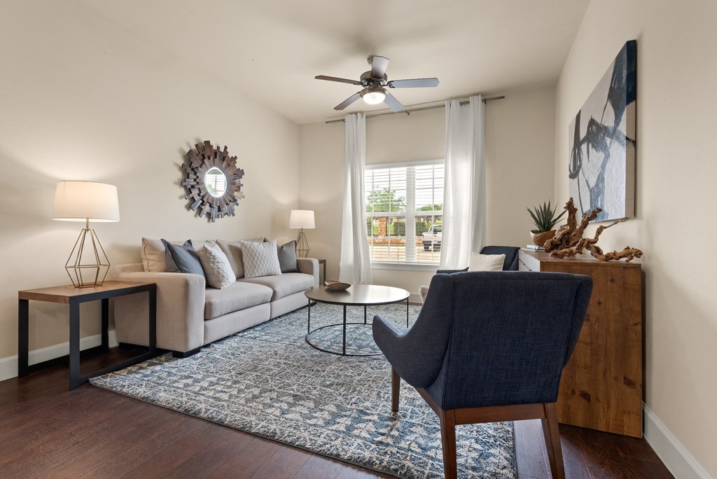 a living room with a couch and a chair and a ceiling fan