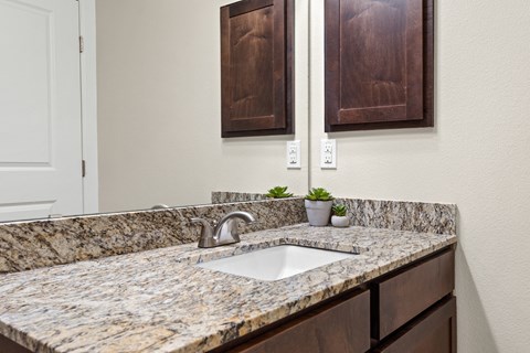 a kitchen counter with a sink and wooden cabinets