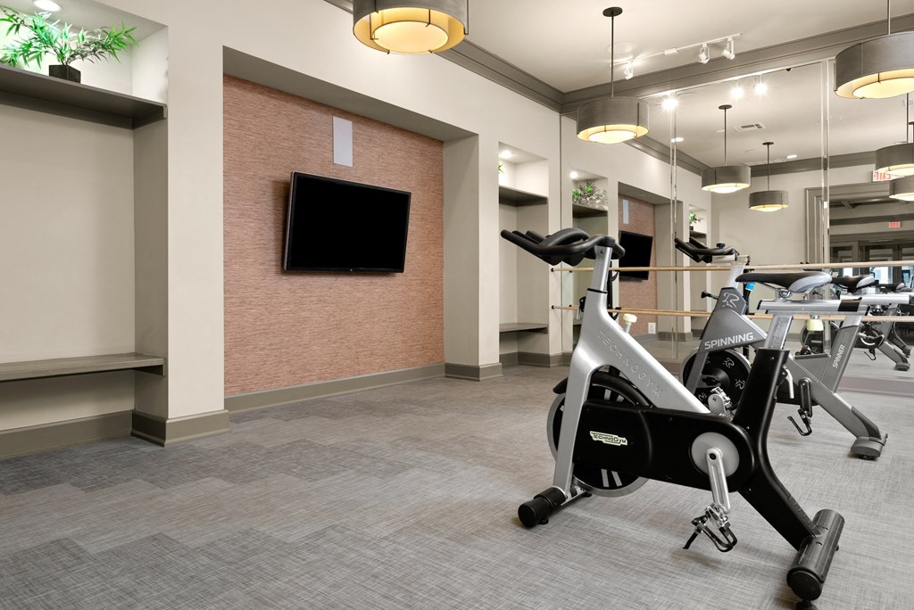 a gym with exercise machines and a tv in the corner