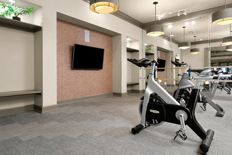 a gym with exercise machines and a tv in the corner