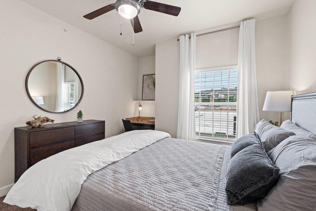 a bedroom with a large bed and a ceiling fan