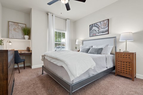 a bedroom with a large bed and a ceiling fan