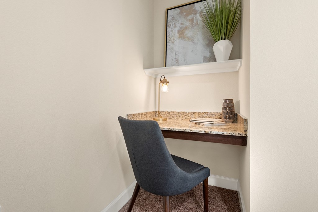 a desk with a chair in a corner of a room