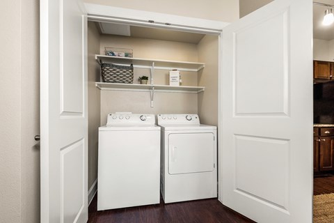 a laundry room with a washer and dryer and a closet with shelves