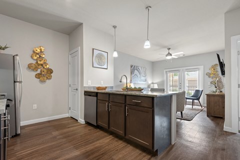 an open kitchen and living room with an island and a dining room table