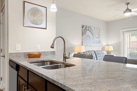 an open kitchen with a large counter top and a sink