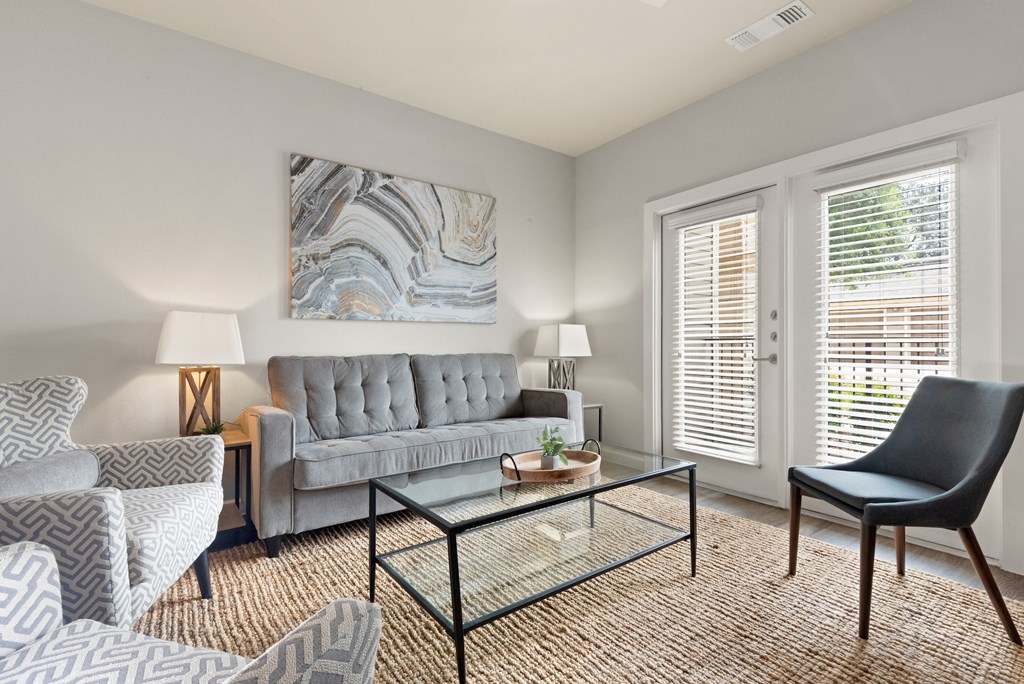 a living room with a couch and chairs and a coffee table