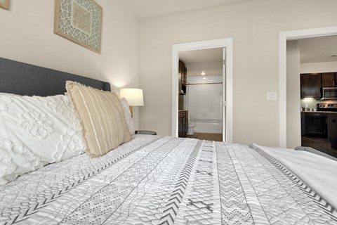 a bedroom with a large bed and a door to a bathroom