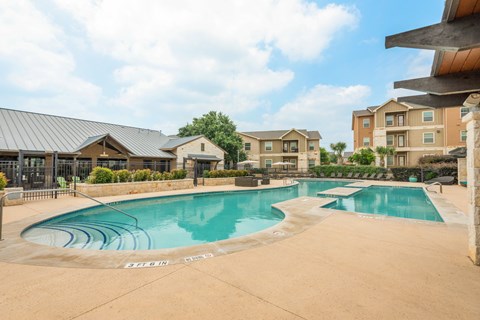 a swimming pool with an apartment building in the background