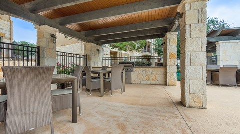a covered patio with tables and chairs