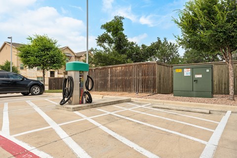 a gas pump in the middle of a parking lot