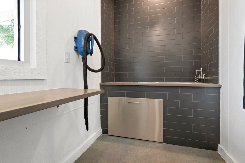 a small laundry room with a dryer and a sink