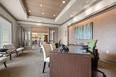 a conference room with a desk and chairs and a large window