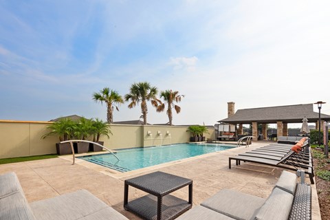 a swimming pool with lounge chairs and palm trees
