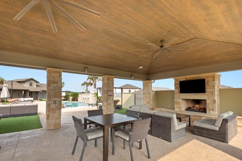 a patio with a table and chairs and a fireplace