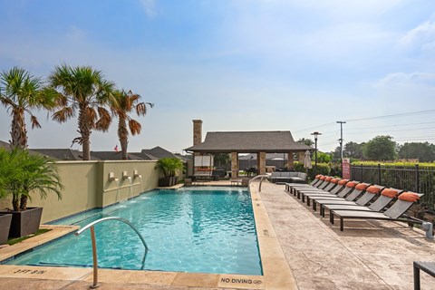 a swimming pool with chairs and a house in the background