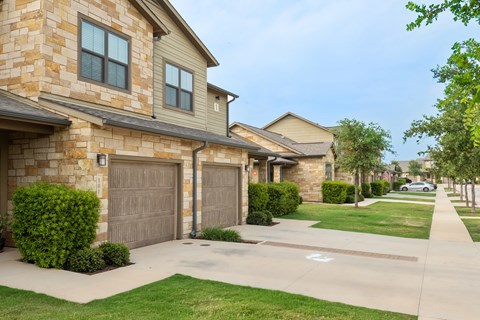a house with two garages and a sidewalk in front of it