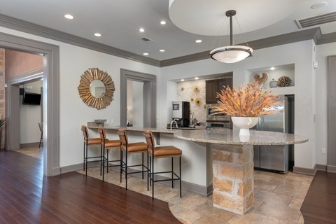 a kitchen with a marble counter top and bar stools