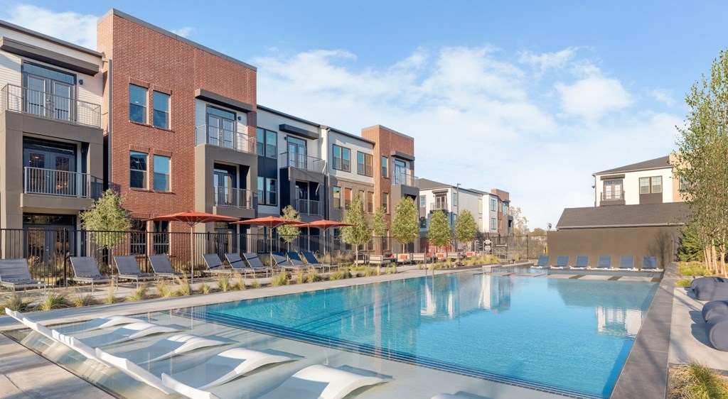 A swimming pool in front of apartment buildings.
