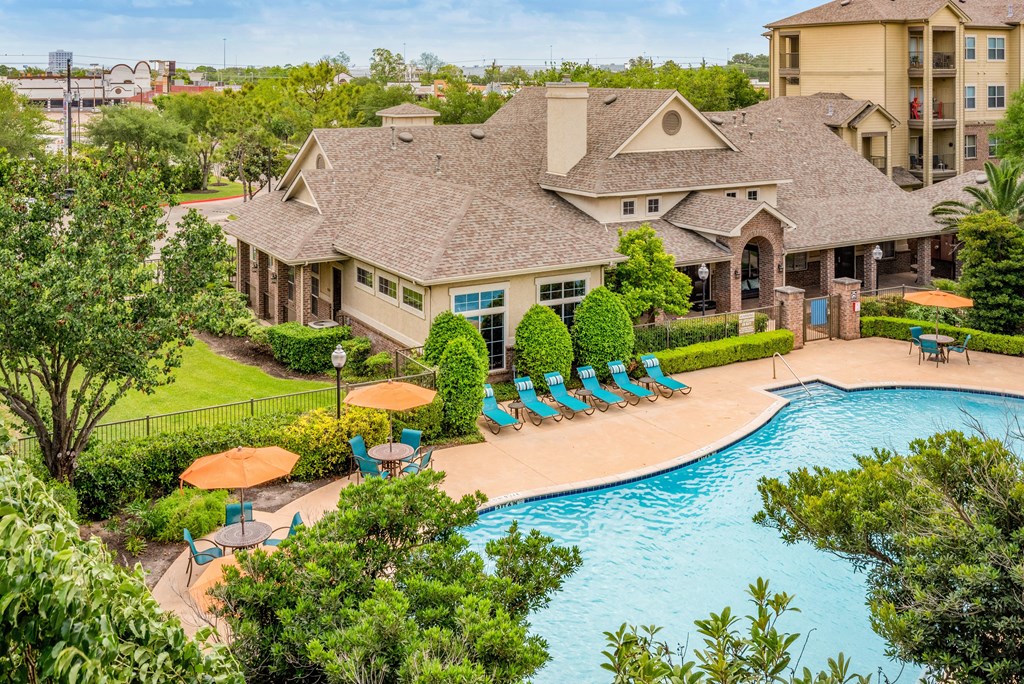 a swimming pool with lounge chairs at the resort on a sunny day